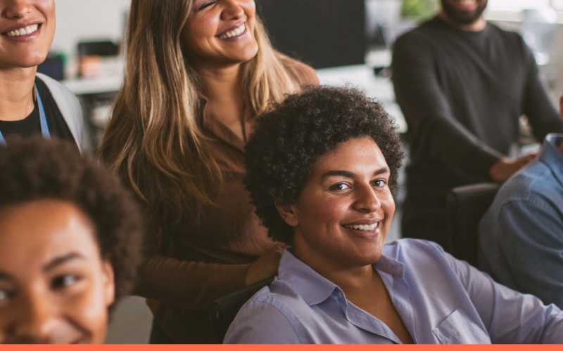Colegas de trabalho sorrindo juntos no escritório, representando felicidade no trabalho