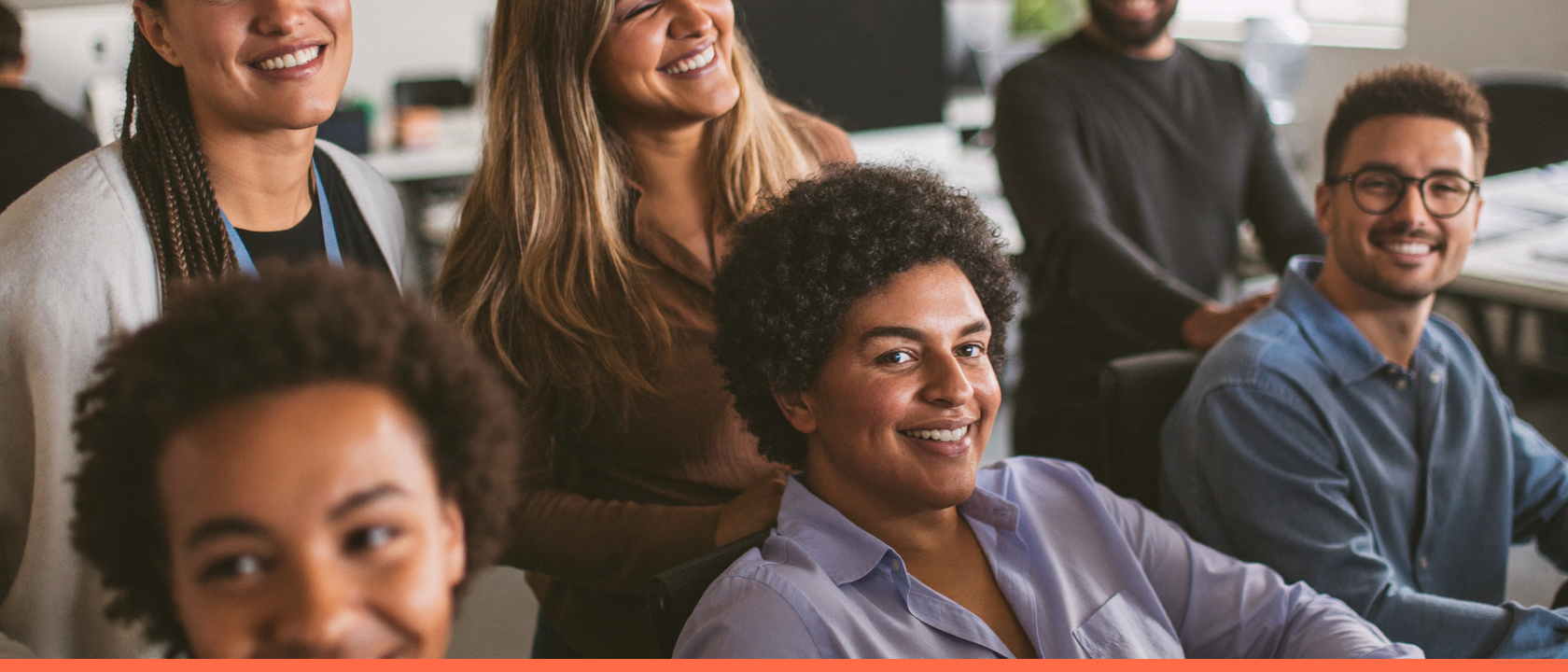 Colegas de trabalho sorrindo juntos no escritório, representando felicidade no trabalho