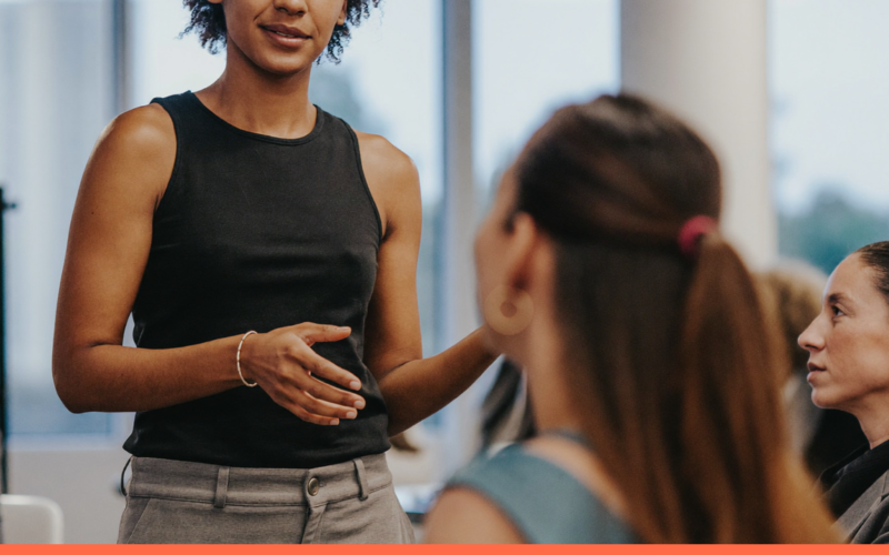 Facilitadora conduzindo uma sessão de aprendizado corporativo com adultos engajados